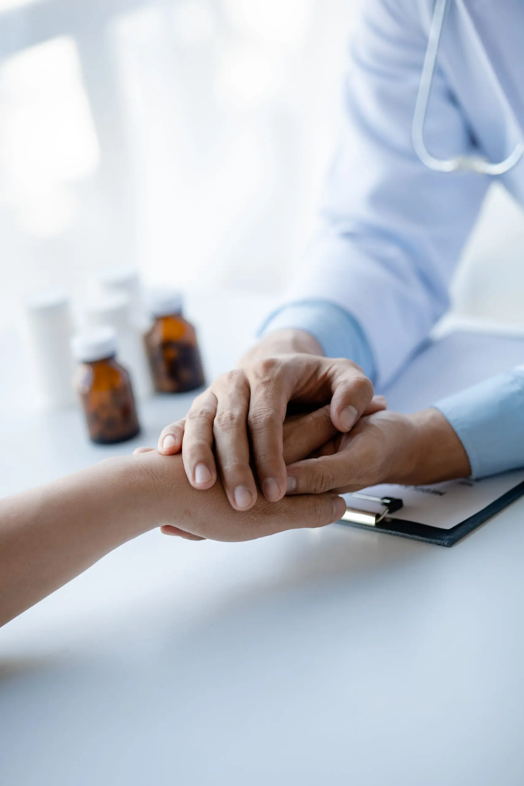 Doctor in white coat reassures patient while giving travel health & vaccination advice; medicine bottles visible.